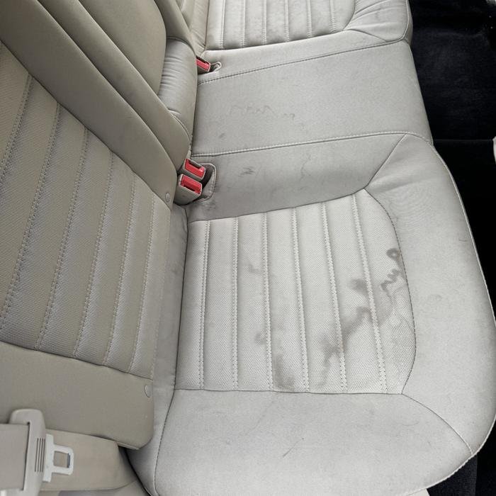 Stained cloth back seat before shampoo