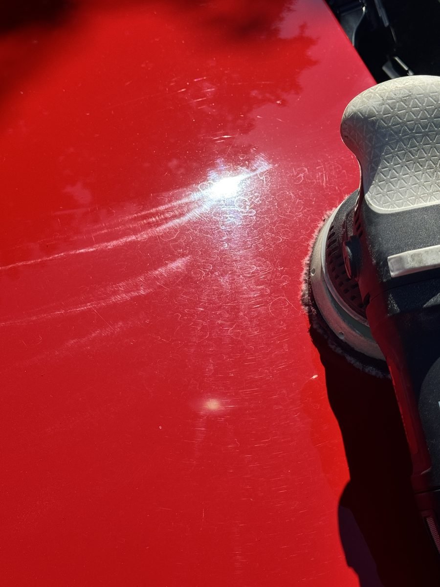 Swirl marks on a red Camaro hood before polishing