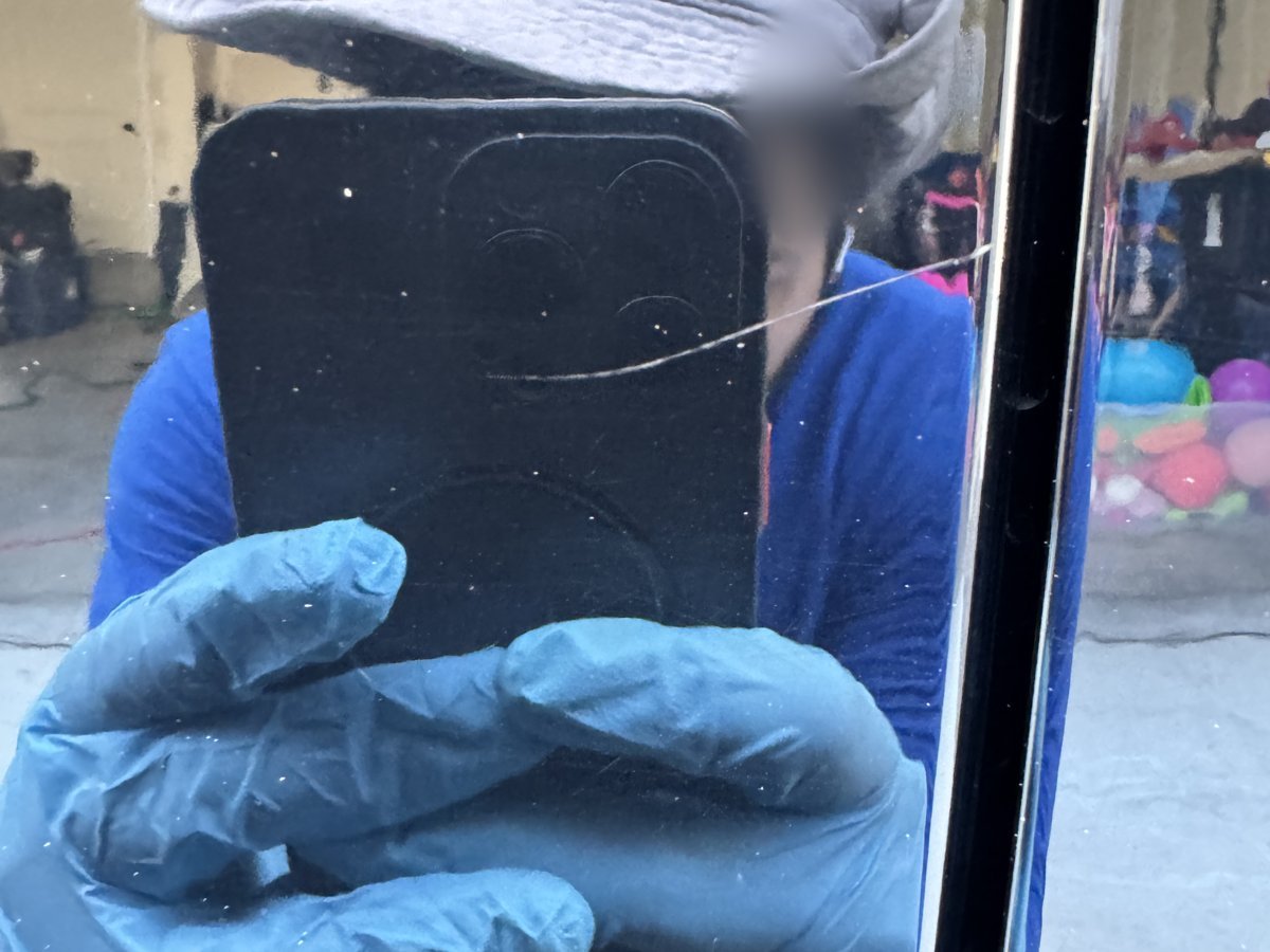 Long scratch on black car door paint before scratch removal